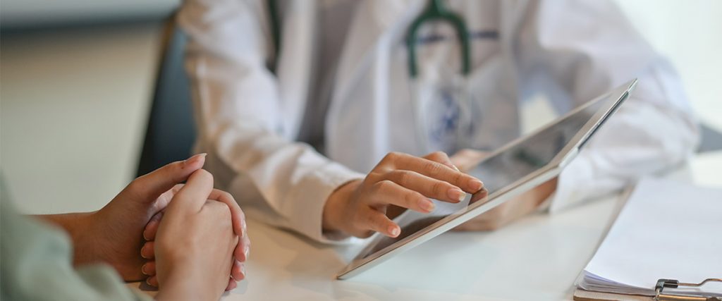 Doctor showing a patient some information on a digital tablet